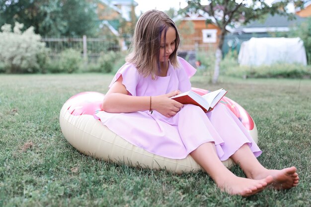 Cute little girl reading book outdoors. summertime rest