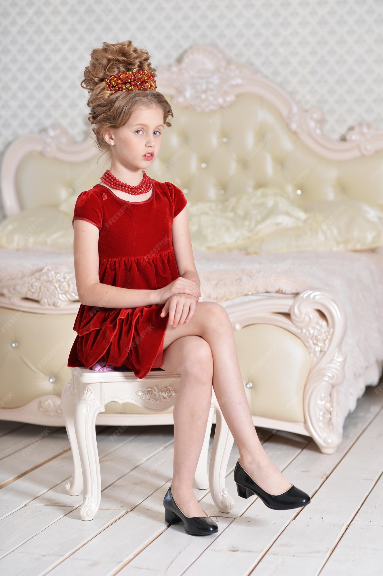 Premium Photo | Cute little girl in red dress sitting in bedroom