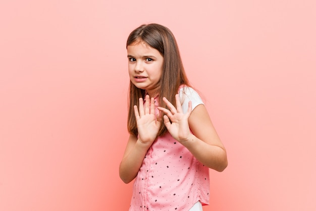 Cute little girl rejecting someone showing a gesture of disgust