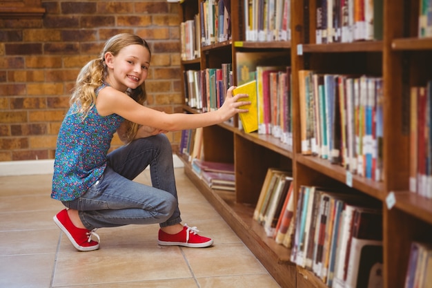 かわいい女の子、図書館で本を選ぶ