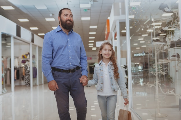 Милая маленькая девочка, покупки в торговом центре с отцом