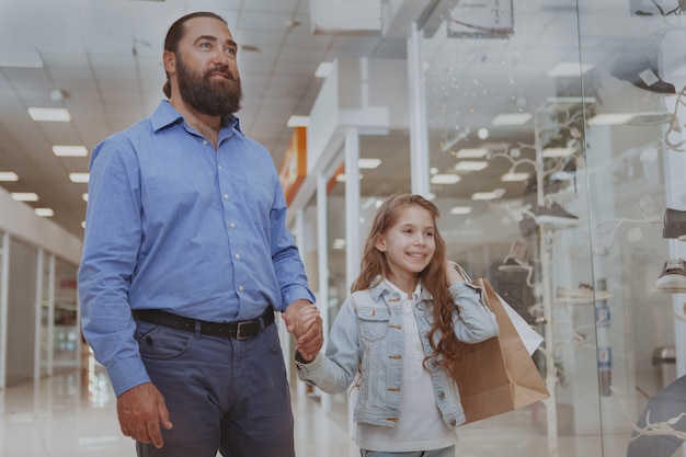 Cute little girl shopping at the mall with her father