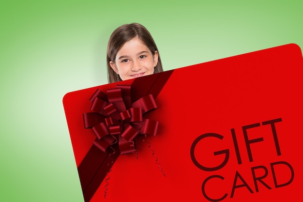 Cute little girl showing card against green vignette