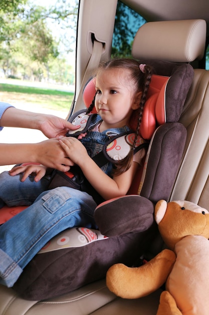 Photo cute little girl sitting in the car