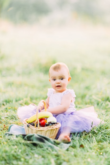 Cute little girl sitting on the grass on a sunny day