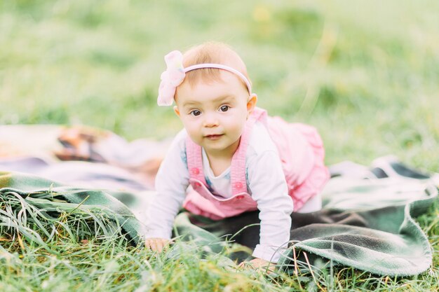 Cute little girl sitting on the grass on a sunny day