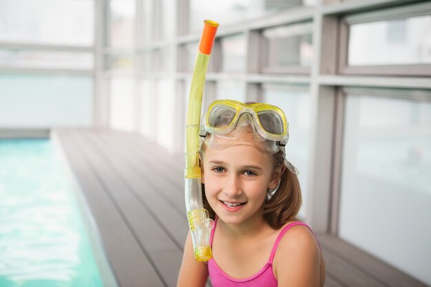 Cute little girl sitting poolside