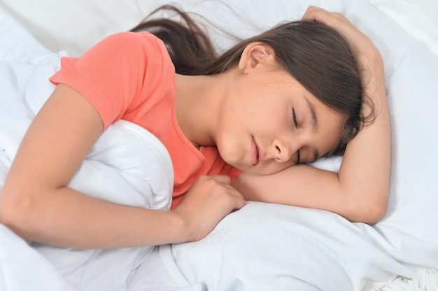 Cute little girl sleeping in bed at home