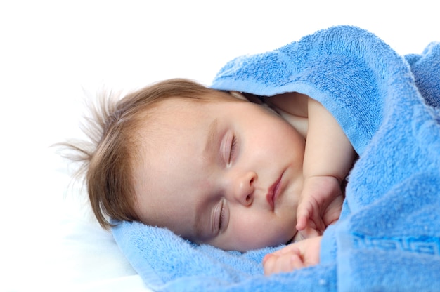 Cute little girl sleeping in a blue towel