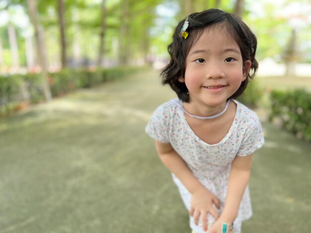 写真 コピースペースのある庭で美しいポーズでかわいい女の子の笑顔