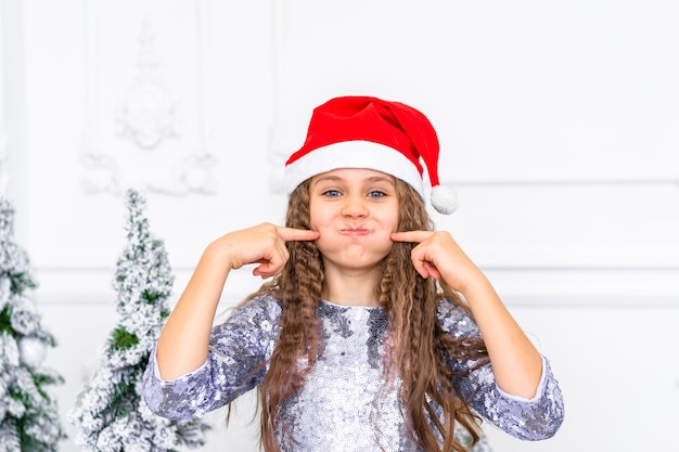 Cute little girl smiles next to with Christmas decorations