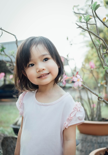 Photo cute little girl smiling at home garden