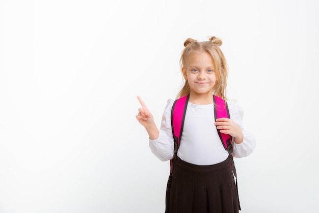 白い背景の上の本のバックパックを保持しているかわいい女の子の制服