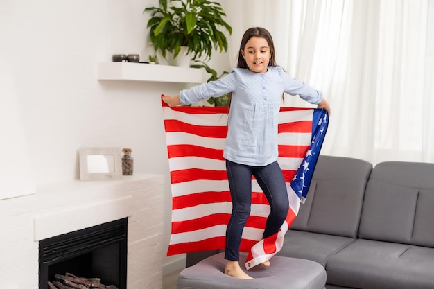 Cute little girl and USA flag on background.