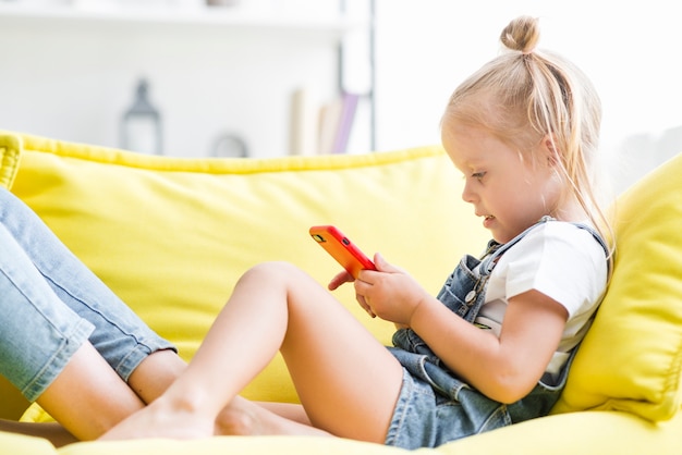 Photo cute little girl using cell phone