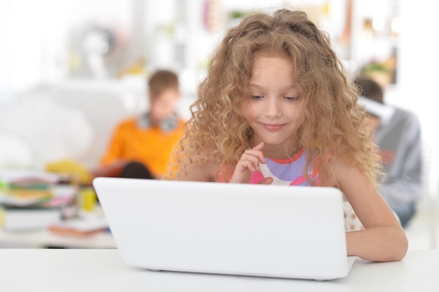 Cute little girl using laptop at class