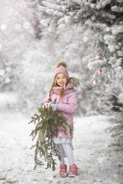 Bambina carina in inverno per strada prima del nuovo anno nella neve