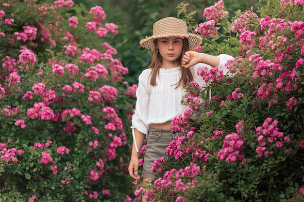 写真 麦わら帽子をかぶった金髪のかわいい女の子 ピンクの花 夏