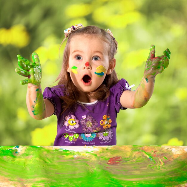 Photo cute little girl with colorful painted hands on  background