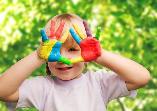 Cute little girl with colorful painted hands on  background