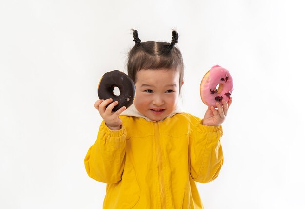 Cute little girl with doughnuts on a white background