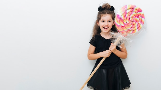 Cute little girl with giant lollipop and copy space