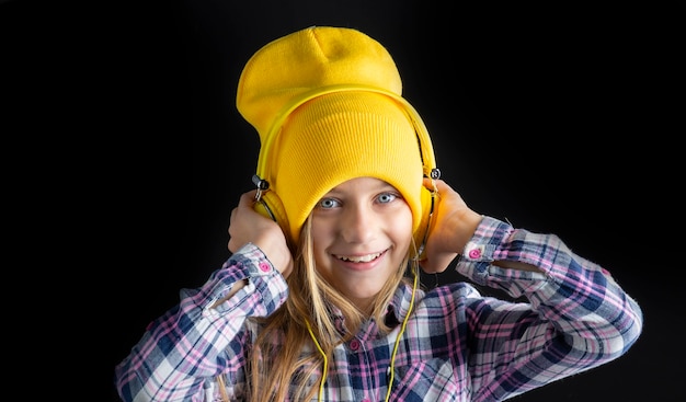 Foto bambina sveglia con un cappello e cuffie