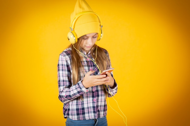 Bambina sveglia con un cappello e cuffie