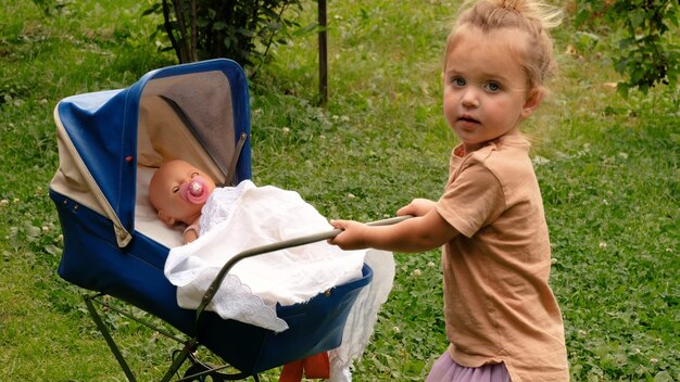 Cute little girl with her toy carriage