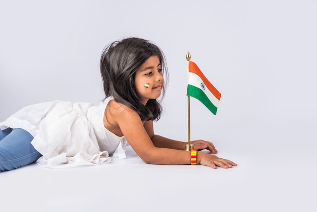 Cute little girl with Indian National Tricolour Flag, Isolated over white background. Suitable for Independence Day or Republic Day concept