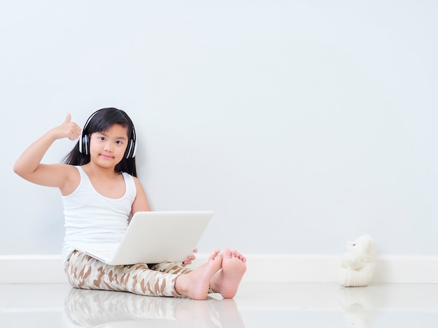 Cute little girl with laptop at home