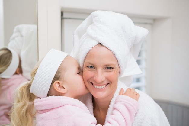 Photo cute little girl with mother in bathrobes