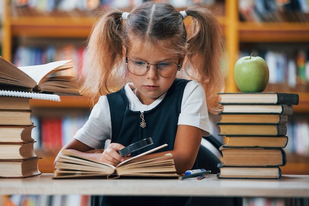 Cute little girl with pigtails is in the library