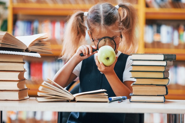 Cute little girl with pigtails is in the library