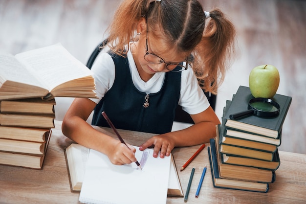 Foto la bambina carina con le trecce è in biblioteca