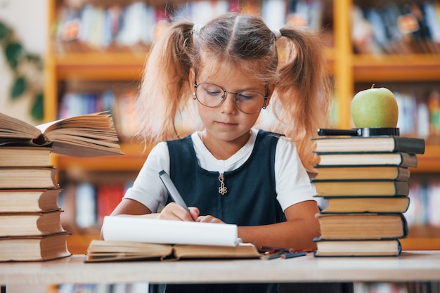 Cute little girl with pigtails is in the library