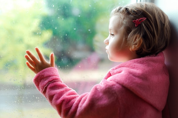 Cute little girl with ponytail in pink bathrobe