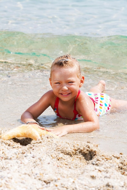 Cute Little girl with starfish on the beach