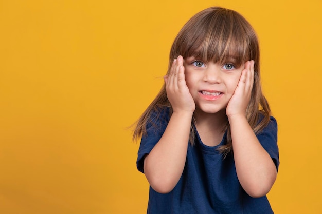 Bambina sveglia con i capelli lisci che sorride dolcemente alla macchina fotografica