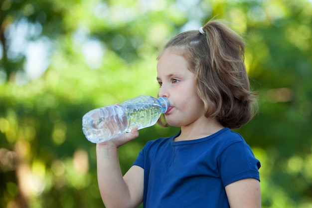 Bambina sveglia con la bottiglia d'acqua