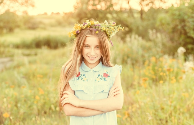 Cute little girl in a wreath of flowers