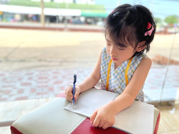 Cute little girl writes on her notebook