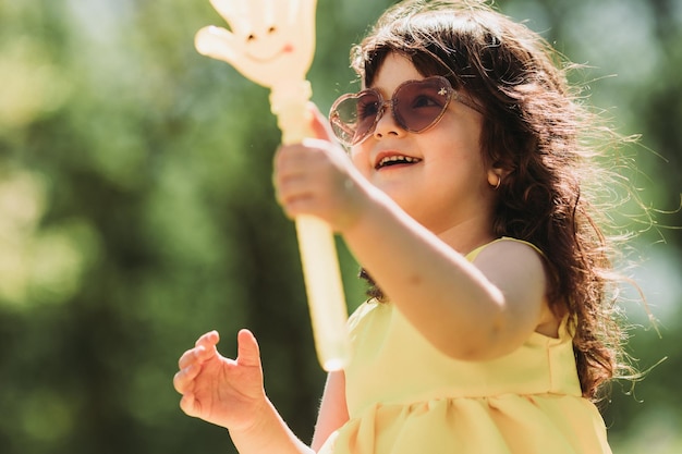 cute little girl in yellow dress playing in park