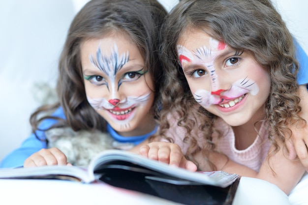Cute little girls with face painted and magazine
