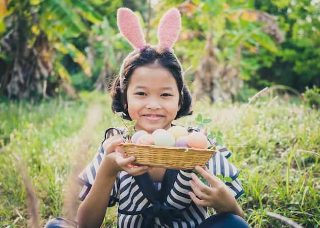 Photo cute little gril with easter eggs.