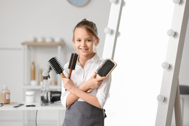 Cute little hairdresser in beauty salon