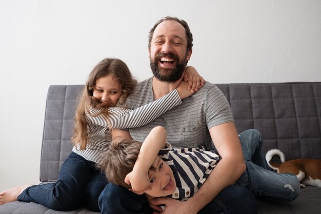 Cute little happy caucasian girl and boy hug father. best friends. Son and daughter. Siblings. happy family. Having fun.