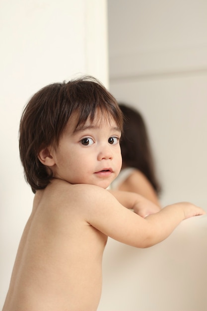 Cute little hispanic boy with back turned face to camera and cookie remnants on face