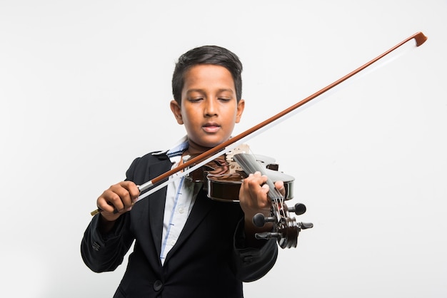 Cute little Indian or asian boy playing violin like a professional, isolated over white background