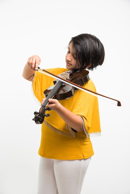 Cute little Indian or asian girl playing violin, isolated over white background